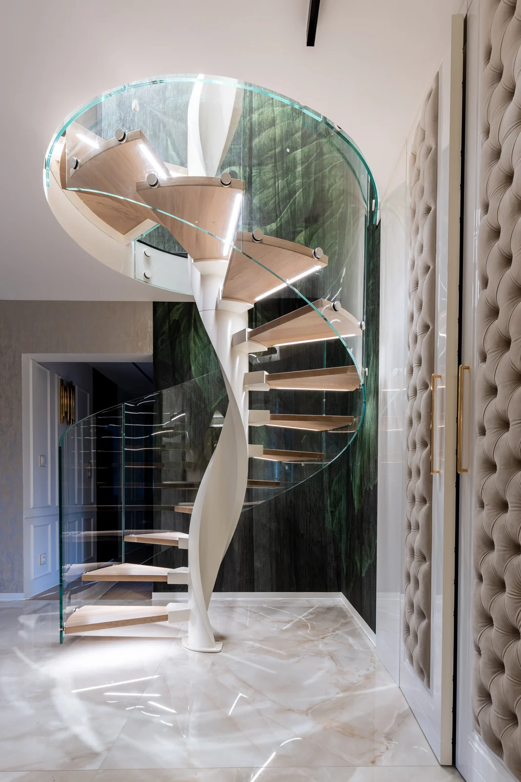 Full view of a spiral staircase with a curved glass balustrade