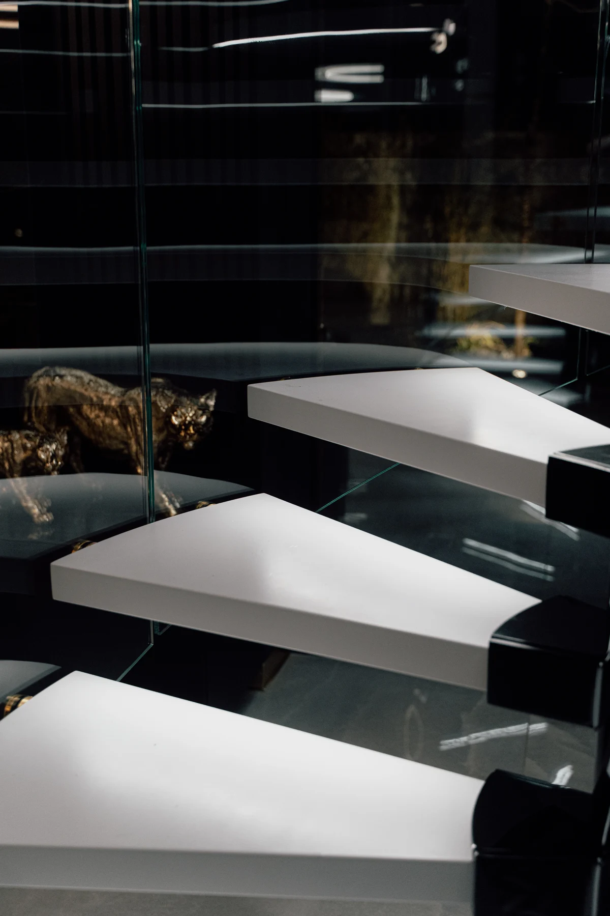 Illuminated light-coloured treads and curved glass balustrade — KAISER project in Poznań
